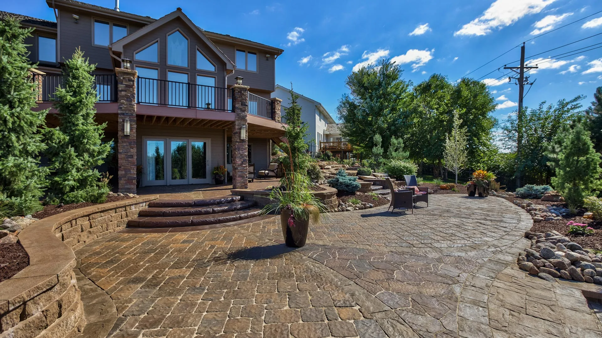 A large paved patio with steps and retaining walls nearby a home in Papillion, NE.