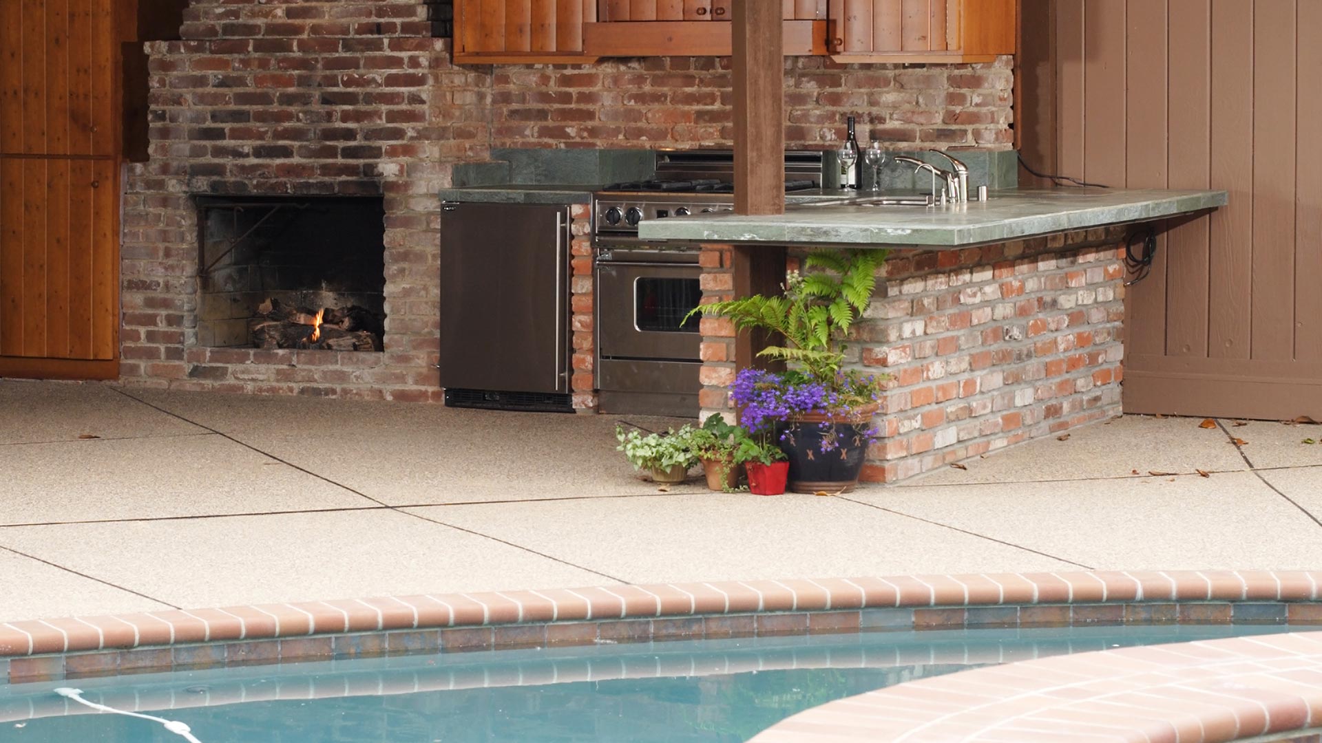 Hardscape features including pool fireplace and outdoor kitchen near Omaha, NE.