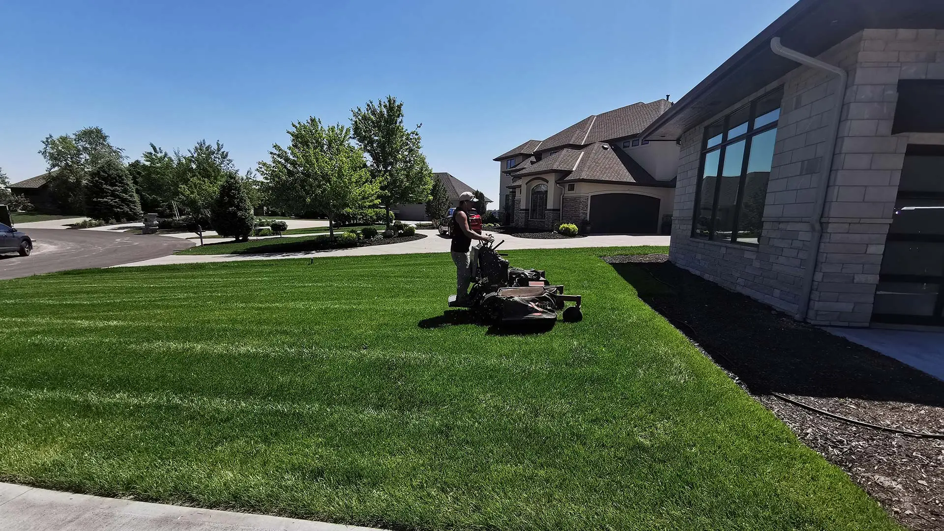 Our landscaper on a lawn mower near a home in Valley, NE.