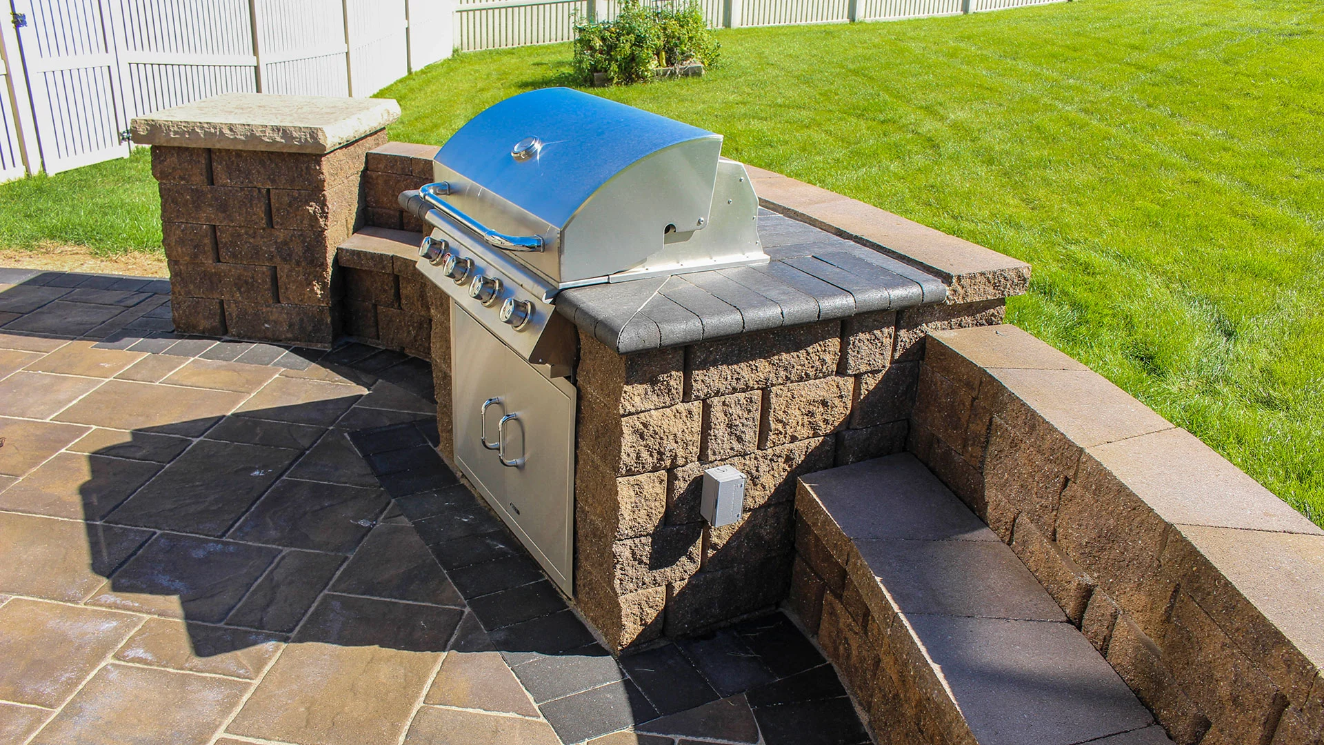 A silver grill surrounded by seating walls on a patio in Bennington, NE.