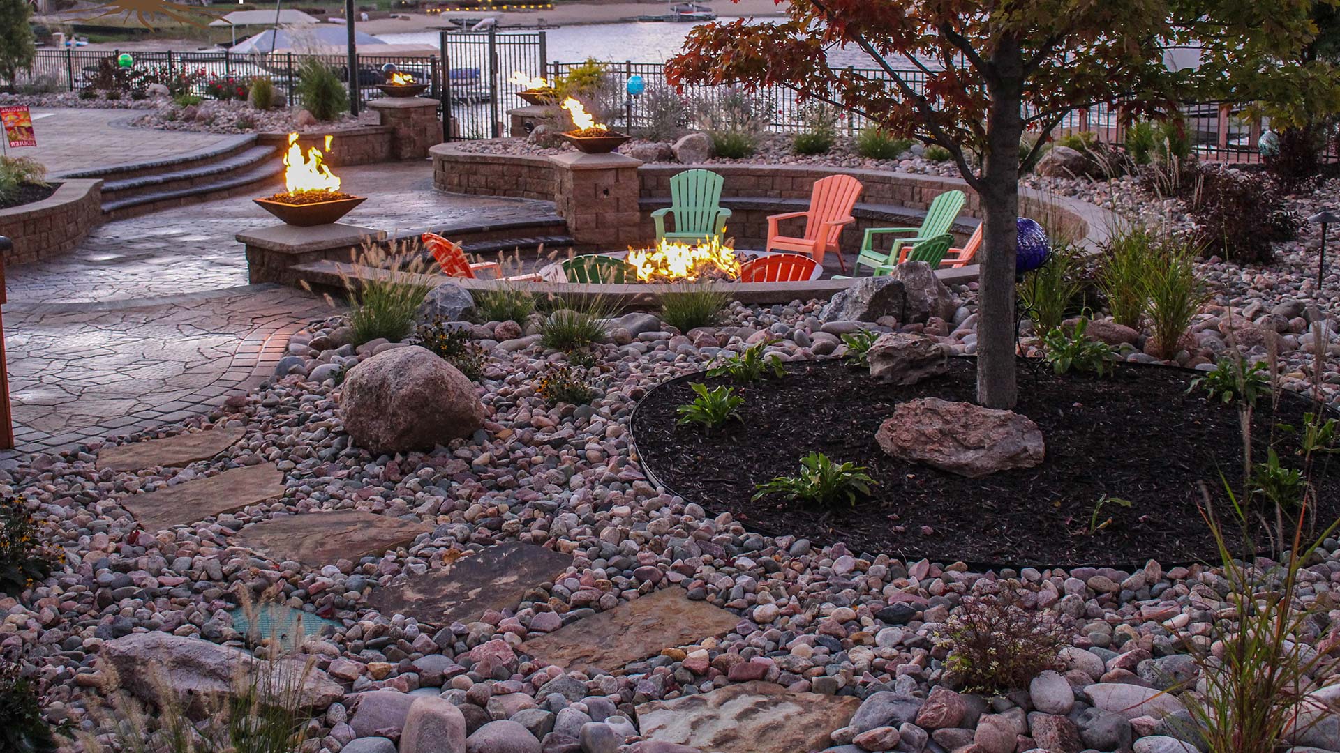 A rock and mulch topped landscape bed alongside a fire pit and retaining wall in Omaha, NE.