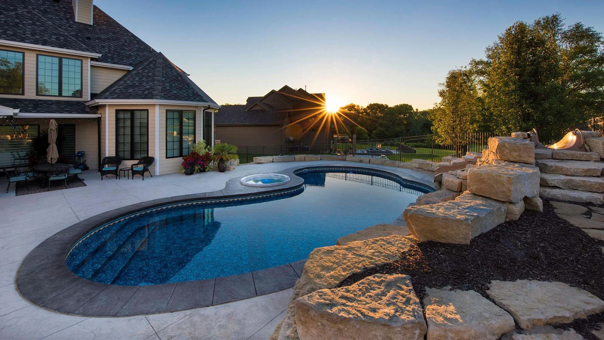 A custom swimming pool and hot tub built near a home in Omaha, NE.