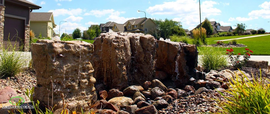 3 bubbling boulders installed in a landscape bed by a home in La Vista, NE.