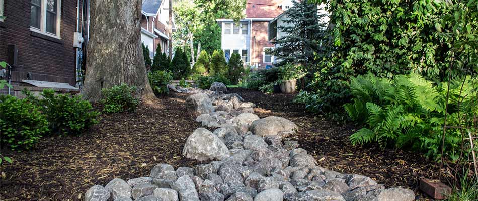 Dry creek bed and rocks installed for drainage in Bellevue, NE.