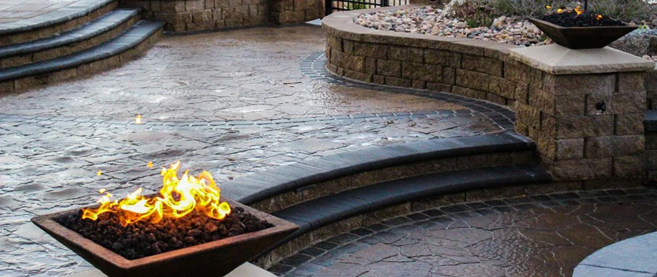 Fire bowls installed on top of retaining walls surrounding a patio in Omaha, NE.