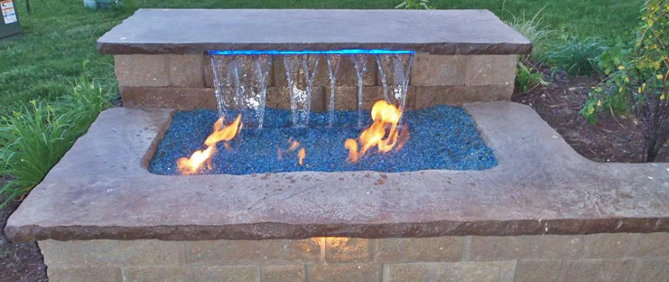 A fire and water feature built with stone near a home in Elkhorn, NE.