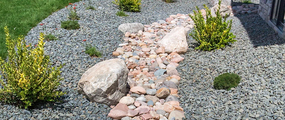 Outdoor drainage solution covered in gray rocks near Waterloo, NE.