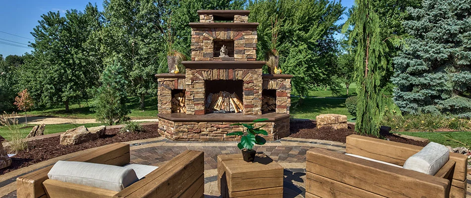 A custom outdoor fire place built on a paved patio by a home in Gretna, NE.