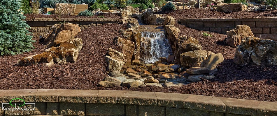 A pondless waterfall installed in a landscape bed by a home in Omaha, NE.