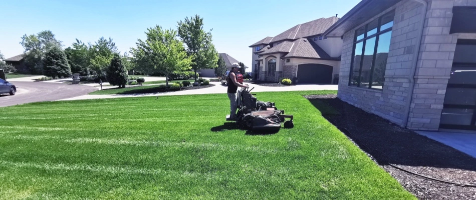 A lawn mowing professional from Groundscapes mowing a lawn with patterns in Elkhorn, NE.