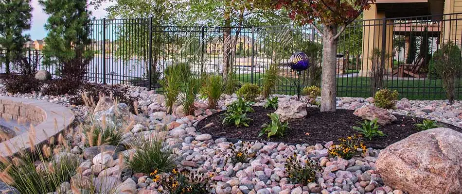 Rock and wood mulch landscape bed around retaining wall in Bennington, NE.