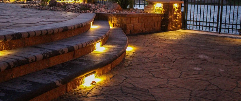 A paved patio with steps lit up with LED lights at nighttime in Gretna, NE.