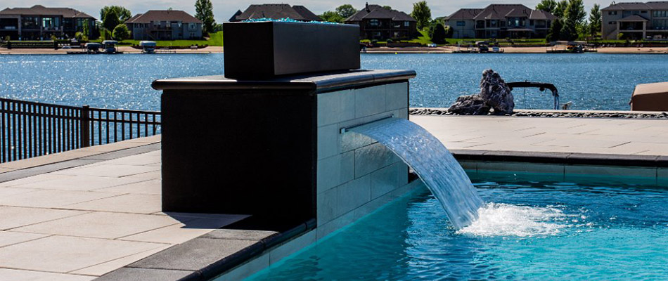 A black and white water weir attached to a pool by a home in Papillion, NE.