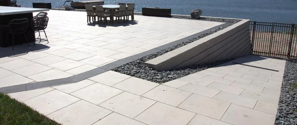 A white patio with grey accents overlooking water nearby a home in Gretna, NE.